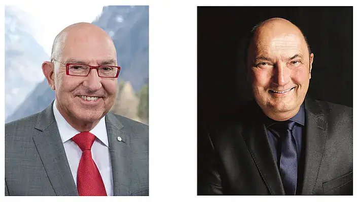 Zwei Männer in formeller Kleidung, lächelnd, professionell.