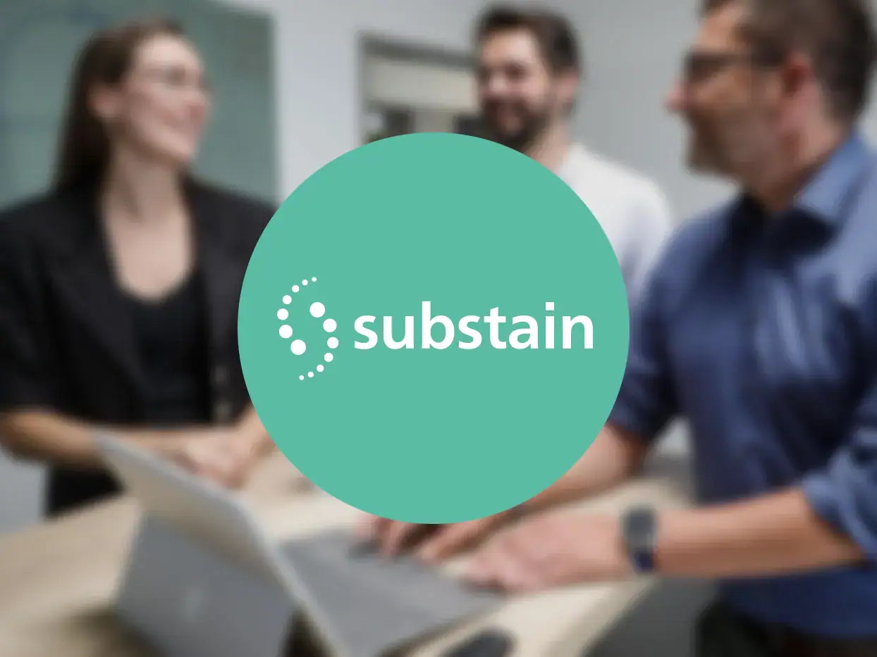 Geschäftsleute bei Meeting mit Substanz Logo im Hintergrund.