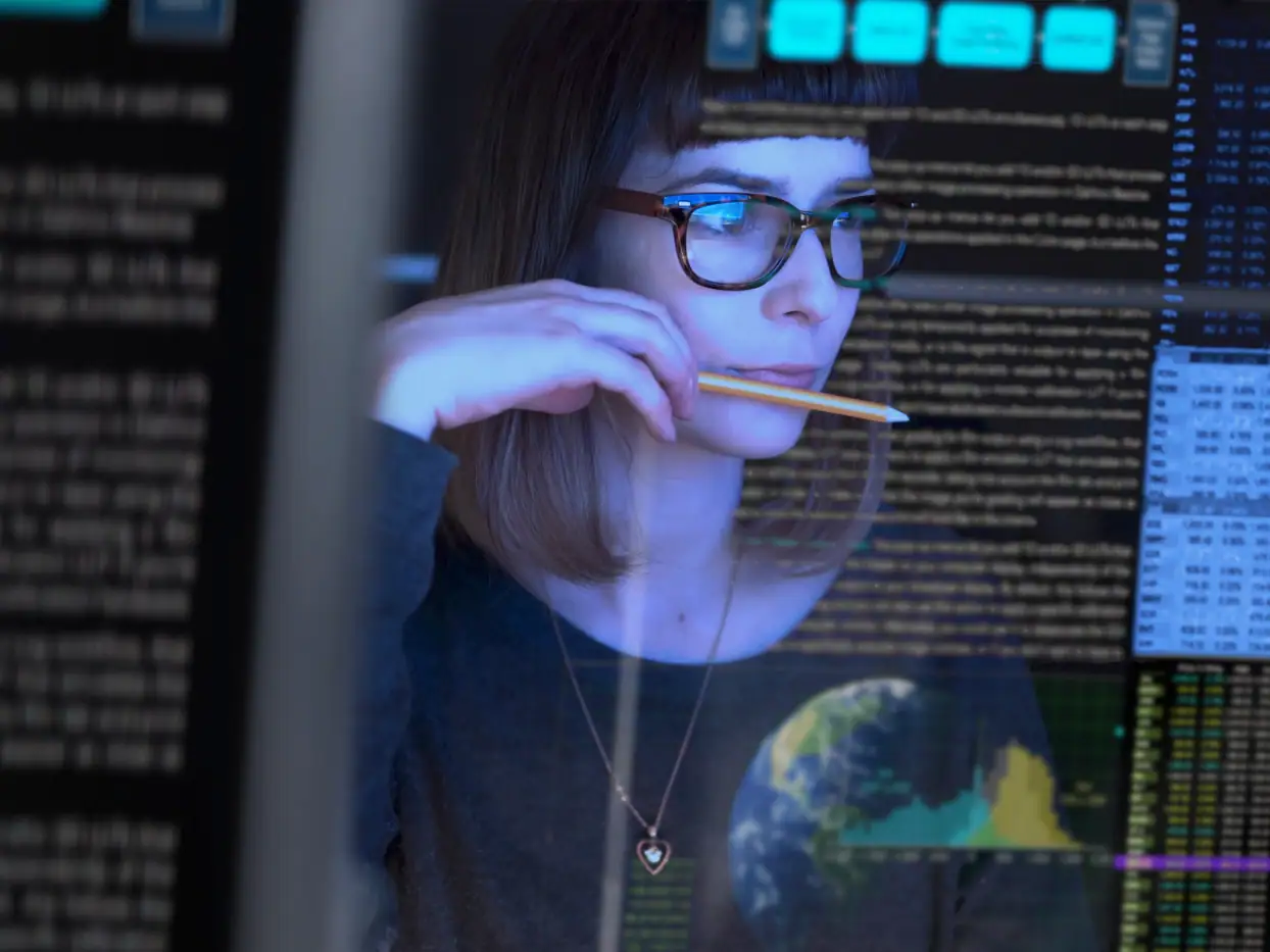 Frau analysiert Daten auf einem Bildschirm im Gebäudemanagement.