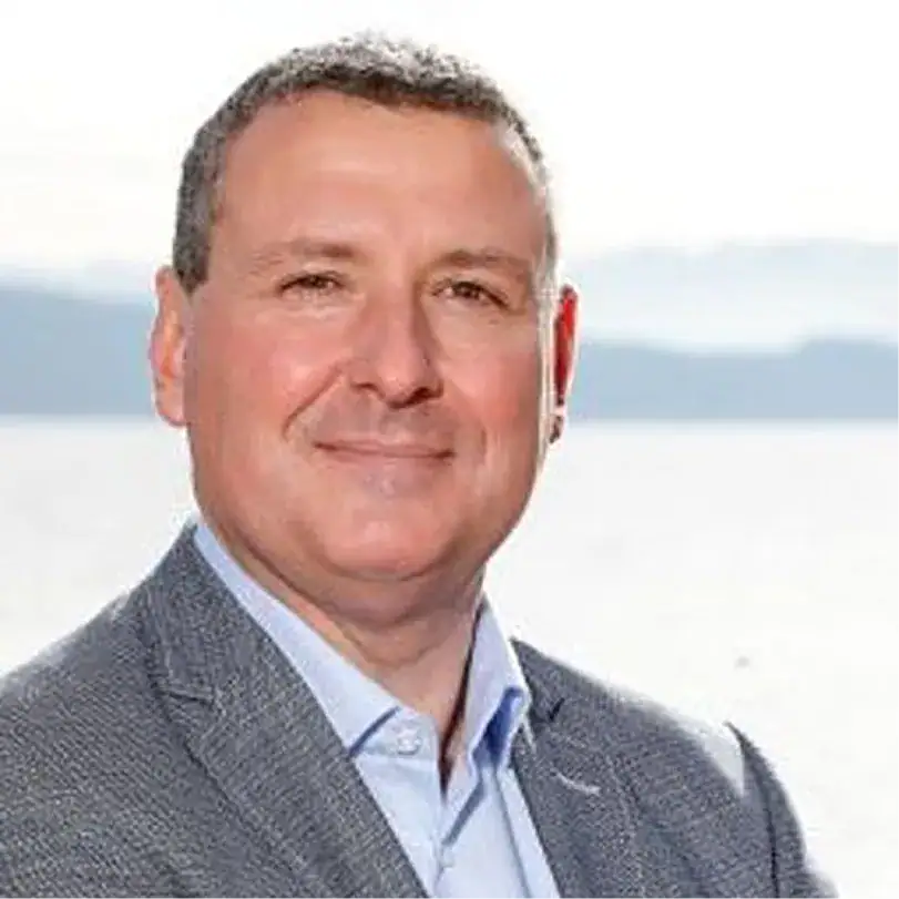 Porträt von Markus Mayr vor Wasserlandschaft, professionell und freundlich.