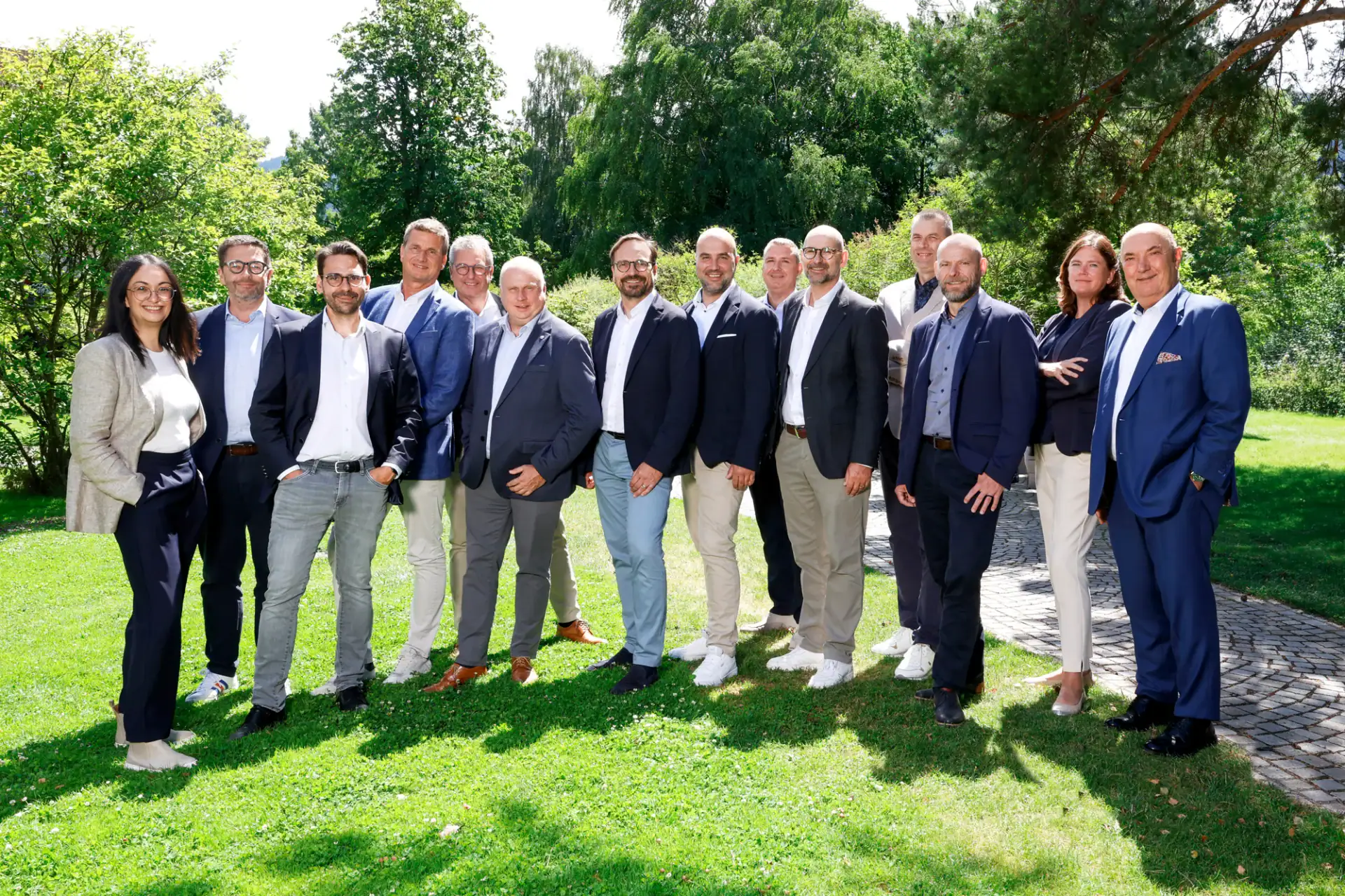 Teamfoto der Wackler Service Group vor grüner Parklandschaft.