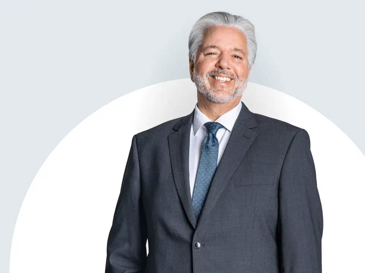 Mann im Anzug, lächelnd, professionell im Gebäudereinigungs- und Facility Management-Bereich.