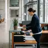 Fachkraft bei Gebäudereinigung mit Reinigungsgeräten in Büro.