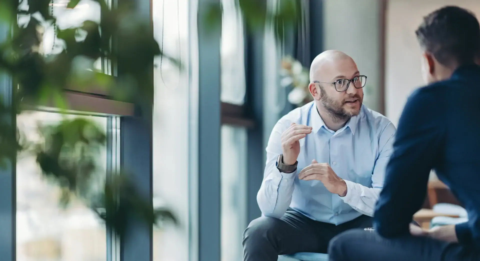 Zwei Männer im Gespräch bei einem Meeting im modernen Büro.