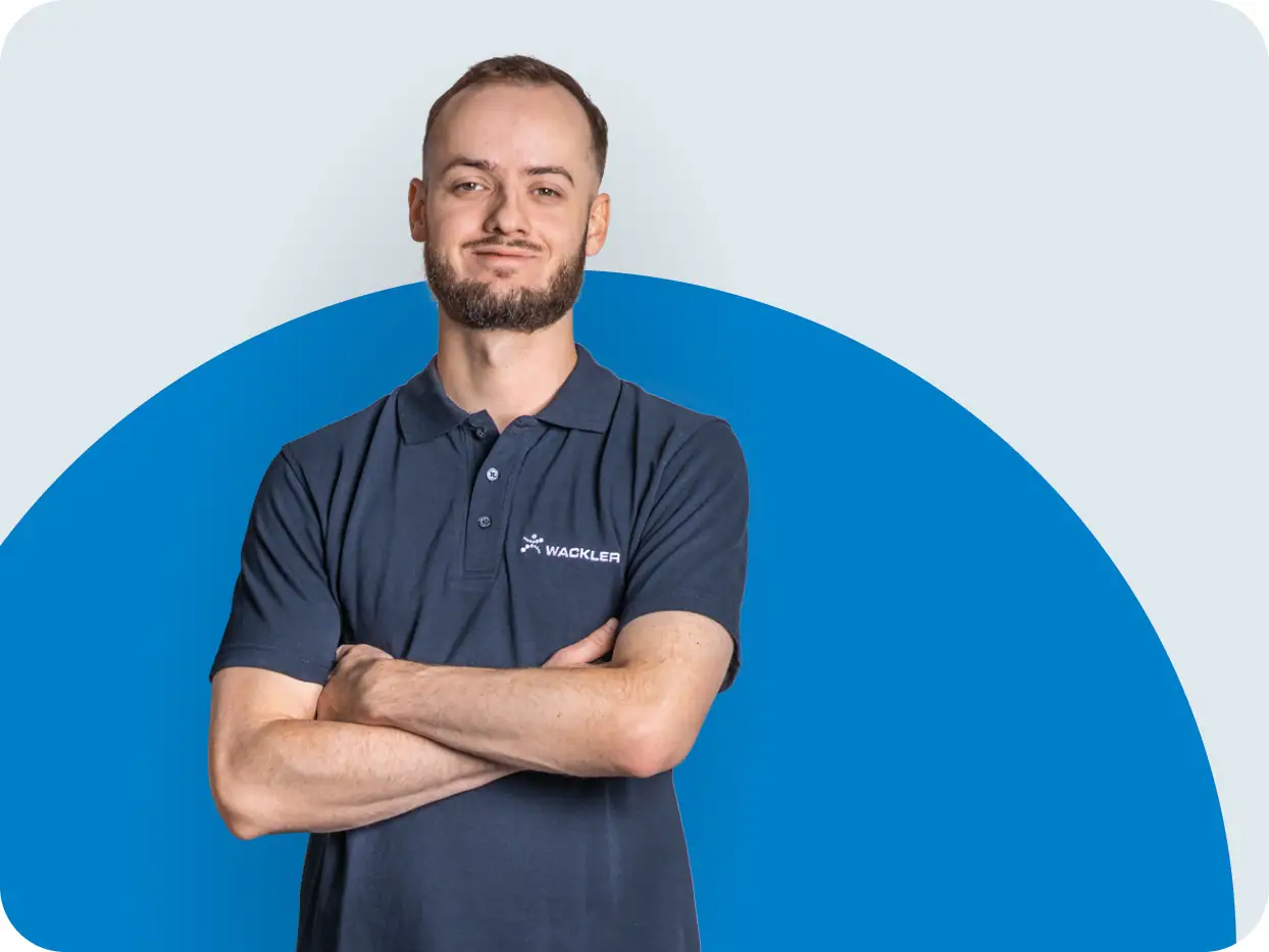 Mitarbeiter der Wackler Service Group in Arbeitskleidung vor blauem Hintergrund.