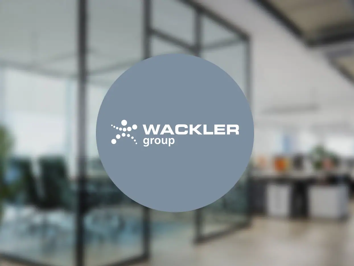 Wackler Group Logo auf Glaswand im modernen Büro.