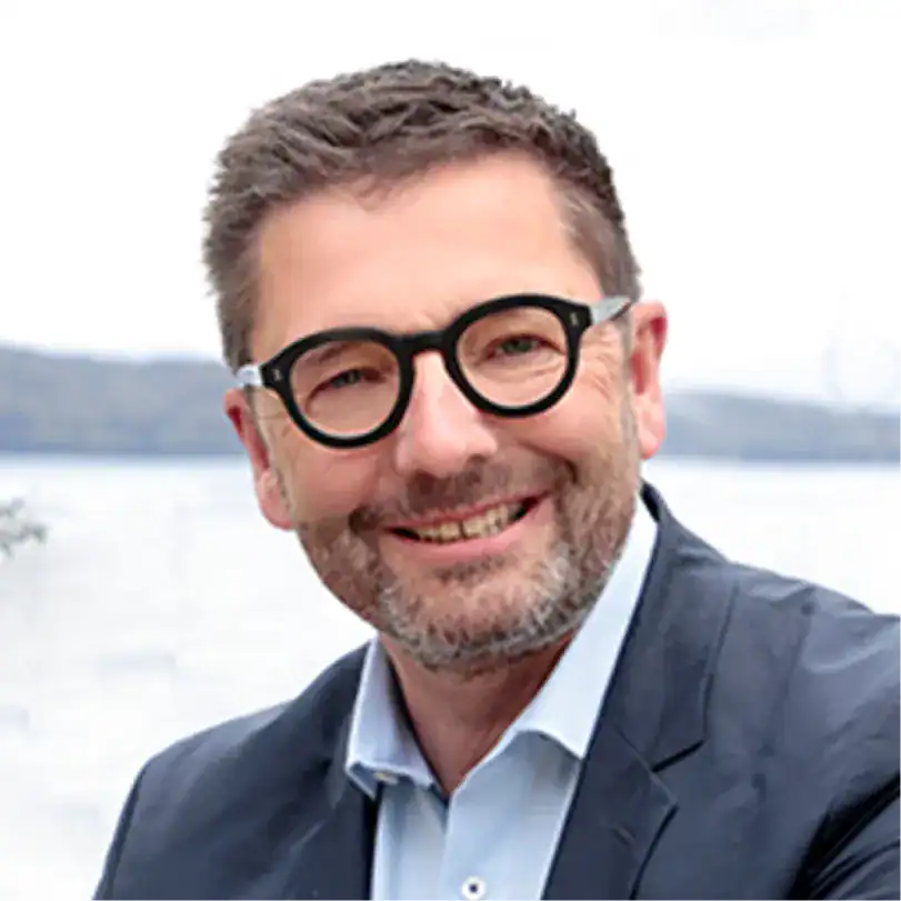 Mann mit Brille und Anzug vor Wasser bei Gebäudereinigung.