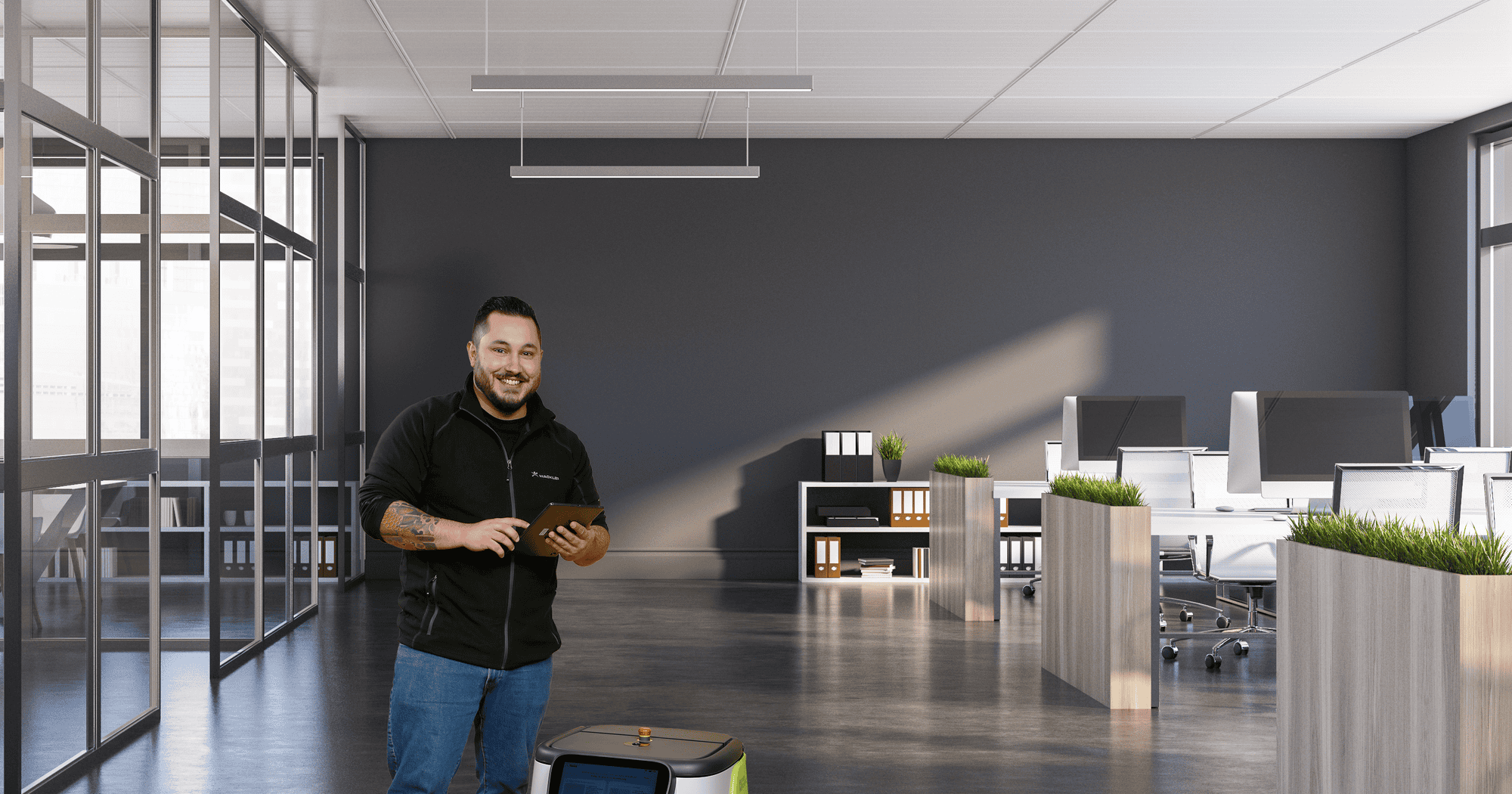 Mann mit Tablet in modernem Büro mit Reinigungsroboter im Vordergrund.