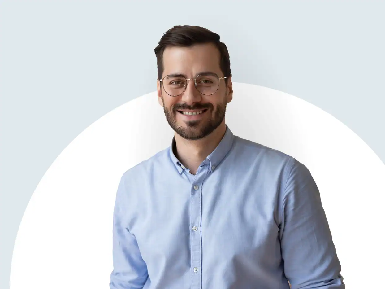 Mann in Hemd und Brille lächelt in die Kamera.