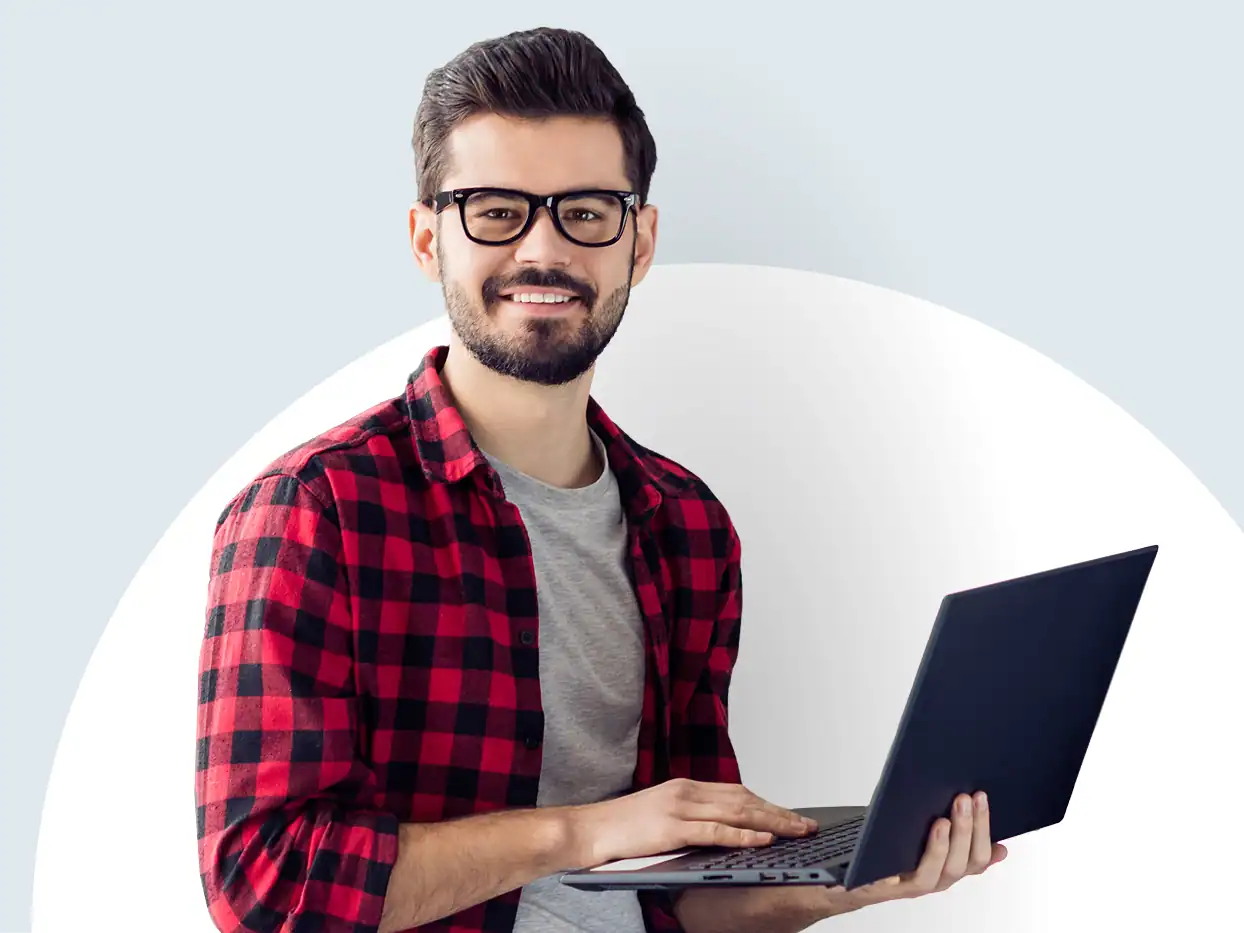 Junger Mann mit Brille und Laptop vor hellem Hintergrund.
