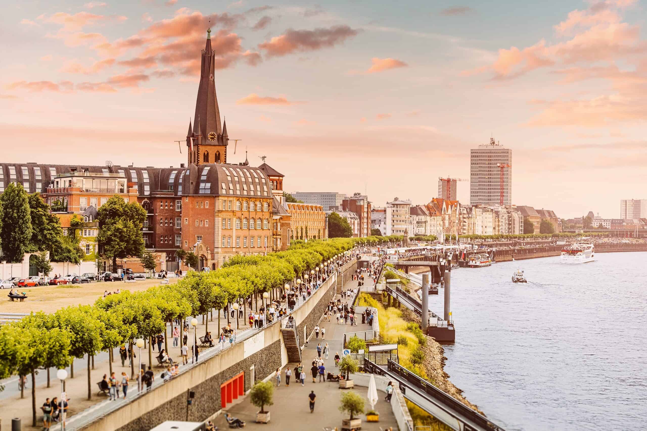 Blick auf den Fluss und die Uferpromenade bei Sonnenuntergang.