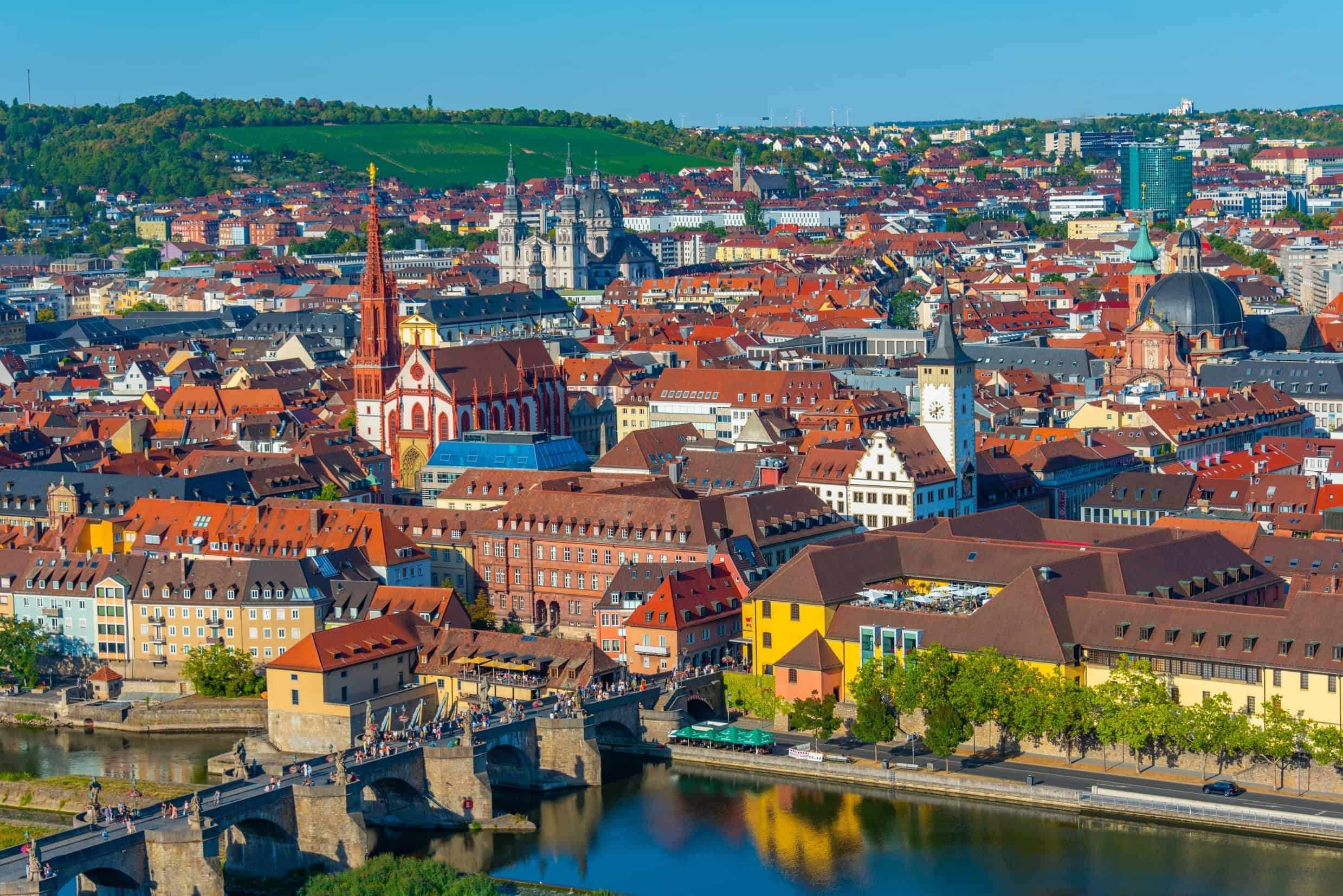 Panoramablick auf eine historische Stadt mit Fluss, Brücken und alten Gebäuden.